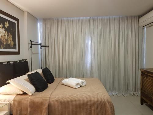 una camera con un letto con due cuscini sopra di Maravilhoso Flat em Itaipava a Itaipava