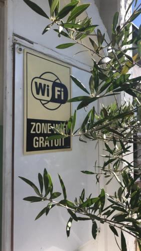 a sign on a wall with a plant at Le 81 HOTEL in Castres