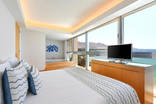 a hotel room with a bed and a tv at Kempinski Hotel Aqaba in Aqaba