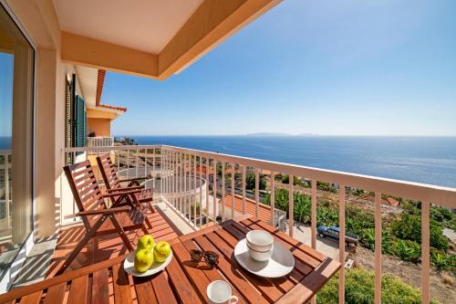 a balcony with a table and chairs and the ocean at Reis Magos III by An Island Apart in Caniço