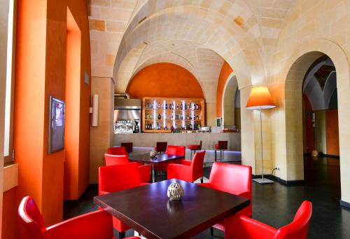 a restaurant with red chairs and tables in a room at Arthotel & Park Lecce in Lecce
