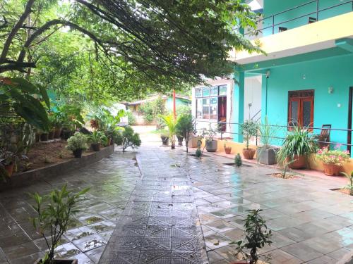 a courtyard with potted plants and a blue building at Sigiri Lion Lodge in Sigiriya