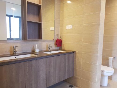 a bathroom with two sinks and a toilet at By The Sea Duplex Condo in Batu Ferringhi
