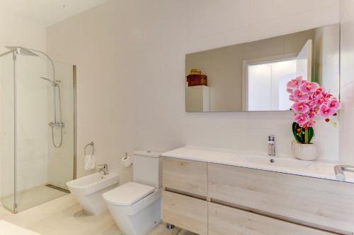 W łazience znajduje się toaleta, umywalka i lustro. w obiekcie Beachfront Apartment Migjorn Playa by Sealand Villas w miejscowości Colonia Sant Jordi