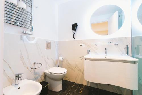 a bathroom with a toilet and a sink and a mirror at San Pietro Grand Suite in Rome