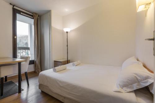 1 dormitorio con cama, escritorio y ventana en Apartment Balme 3B, en Chamonix-Mont-Blanc