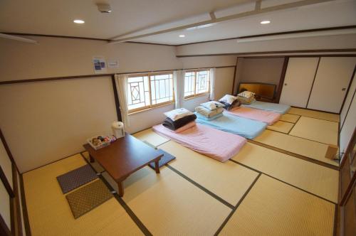 una vista sul soffitto di una camera con 2 letti e un tavolo di Guesthouse Arakura a Fujiyoshida