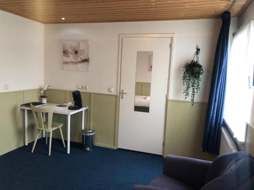 an office with a desk and a table and a door at Hotel Verhoeven in Uden