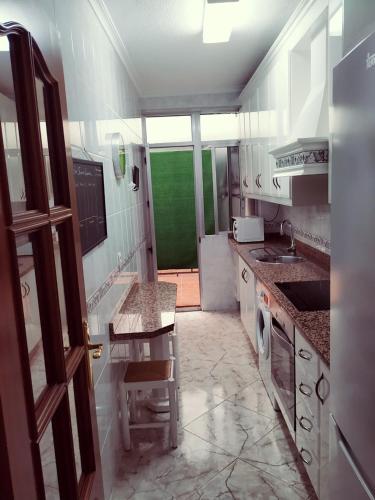 una cocina con armarios blancos y una puerta verde en ARRECIFE, GARAJE Y WIFI GRATIS JUNTO PUENTE ROMANO, en Córdoba