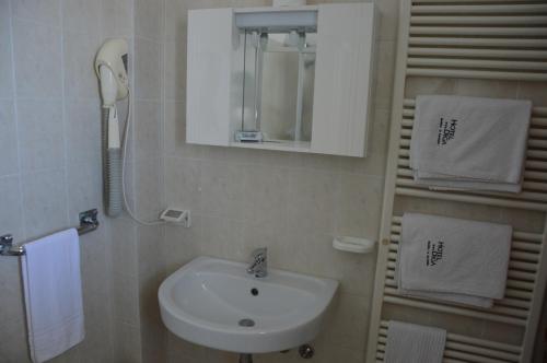 baño con lavabo, espejo y teléfono en Hotel Diga en Marina di Ravenna