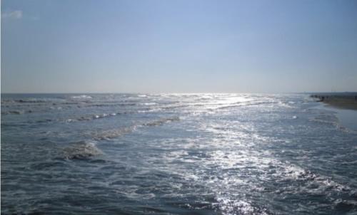 a body of water with the sun shining on it at Hotel Diga in Marina di Ravenna