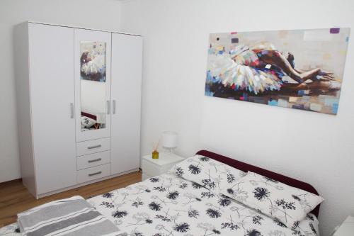 a bedroom with a bed and a painting on the wall at Apartman Zen in Osijek
