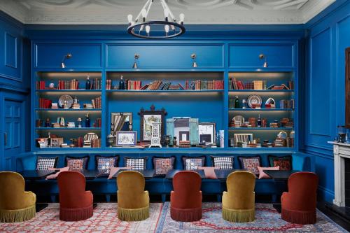 a blue library with chairs and bookshelves at Kimpton Charlotte Square by IHG in Edinburgh