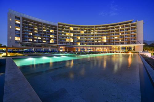 a large building with a swimming pool at night at Kempinski Hotel Aqaba in Aqaba