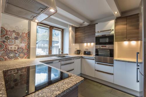 - une cuisine avec des placards en bois et des appareils blancs dans l'établissement Apartment Germain Close to Chamonix Mont Blanc, à Chamonix-Mont-Blanc