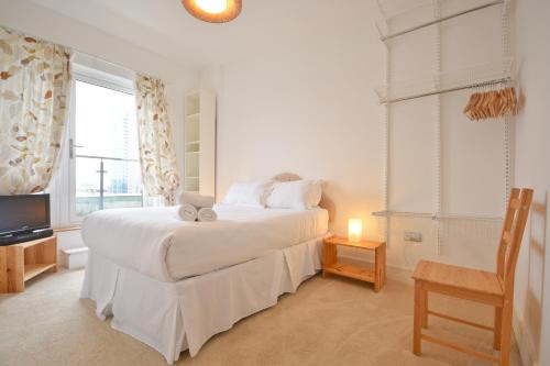 een slaapkamer met een bed, een stoel en een televisie bij Town or Country - Splash B in Southampton