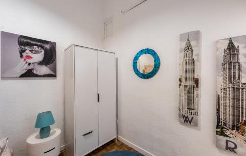 a room with a white cabinet and pictures on the wall at M&F Apartaments Chueca in Madrid