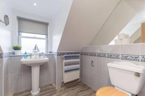 a bathroom with a sink and a toilet and a window at The Steadings - by StayDunfermline in Dunfermline