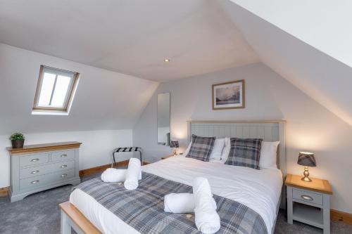 1 dormitorio con 1 cama con sábanas y almohadas blancas en The Steadings - by StayDunfermline, en Dunfermline