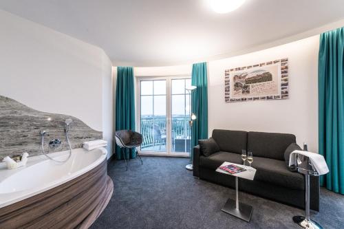 a living room with a bath tub and a couch at Parkhotel Hachenburg in Hachenburg