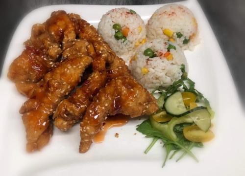 a plate of food with chicken and rice and vegetables at Jolán Pension & Restaurant in Číčov