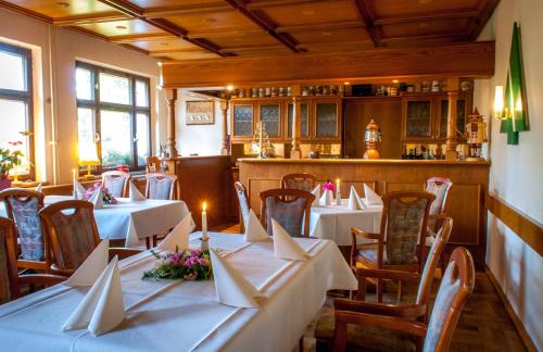 un restaurant avec tables et chaises et nappes blanches dans l'établissement Ferienhotel Augustusburg, à Augustusburg