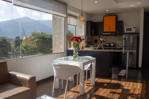 une cuisine avec une table avec un vase de fleurs dessus dans l'établissement Hotel 104 Art Suites, à Bogotá