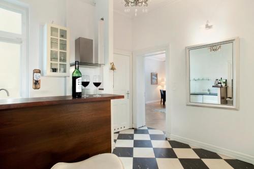 a kitchen with a bar with a bottle of wine at Elite Apartments Sopot Admiralski przy plaży in Sopot