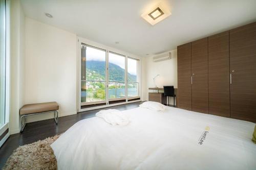 a bedroom with a large bed with a large window at Luxury Apartment Lake View & Center of Montreux by GuestLee in Montreux