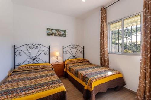 2 camas en una habitación con ventana en Cortijo Tomé, en Torrox