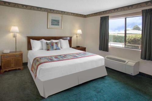 pokój hotelowy z dużym łóżkiem i oknem w obiekcie Travelodge by Wyndham Costa Mesa Newport Beach Hacienda w mieście Costa Mesa