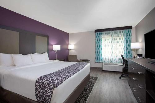 a hotel room with a large bed and a desk at La Quinta Inn by Wyndham Roanoke Salem in Salem