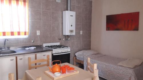 a kitchen with a table and a sink and a stove at Complejo Marce in Ostende
