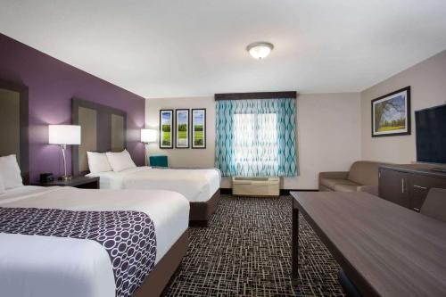 a hotel room with two beds and a couch at La Quinta Inn by Wyndham Roanoke Salem in Salem