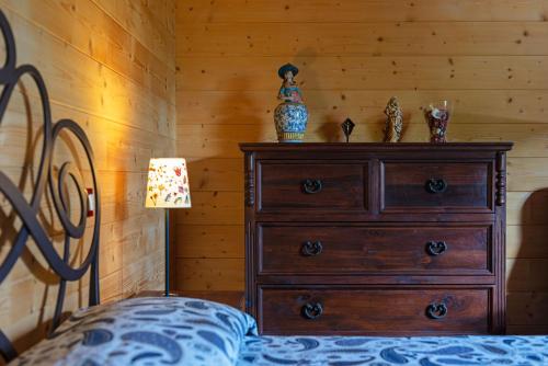ein Schlafzimmer mit einer Kommode und einem Bett mit einer Lampe in der Unterkunft Chalet Scordapeni in Santa Maria di Licodia