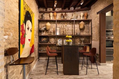 una cocina con una barra con sillas y una pintura en HSH Select Casa Pilatos, en Sevilla