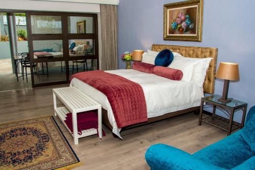 a bedroom with a bed and a couch and a chair at Beds@Paarl in Paarl