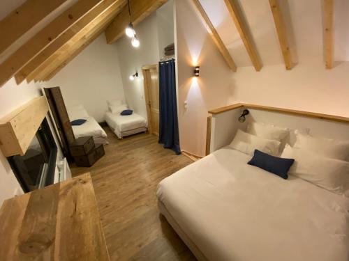 um quarto com uma cama e uma cadeira num quarto em Le Cabanon de LaFermeDuNol em La Bresse