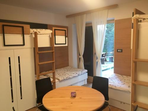 a room with a table and chairs and bunk beds at Apartma Rogla - Gaber 98 in Resnik