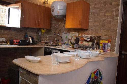 a kitchen counter with bowls and glasses on it at Om-Abdallah in Aswan