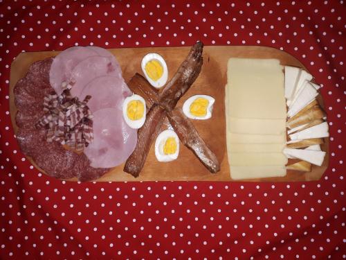 un plato de comida con queso, carne y huevos en OPG DIJANA, en Kopačevo