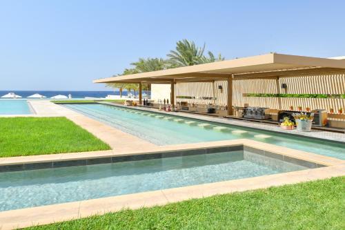 a swimming pool in front of a house at Kempinski Hotel Aqaba in Aqaba