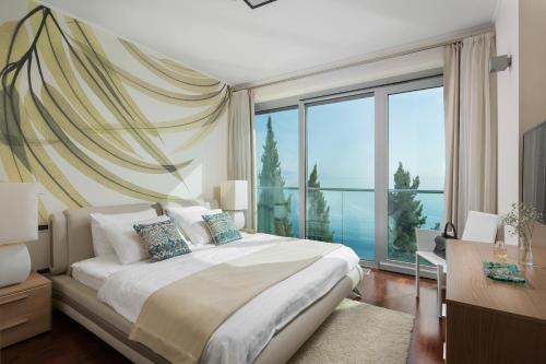 1 dormitorio con cama grande y ventana grande en Villa Arentz Residence - Front Sea Apartments, en Opatija