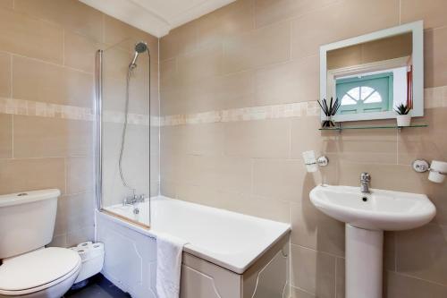 a bathroom with a toilet and a sink and a shower at WelcomeStay Tooting Broadway 3 Bedroom Apartment in London