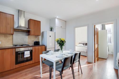 a kitchen and dining room with a table and chairs at WelcomeStay Tooting Broadway 3 Bedroom Apartment in London