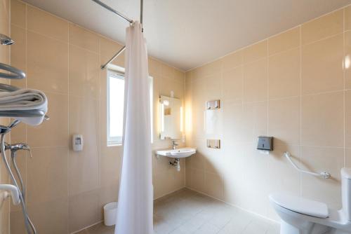 a bathroom with a shower and a sink at B&B HOTEL Lyon Sud États-Unis in Vénissieux