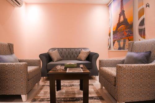 a living room with a couch and two chairs at Loluat Al Matar Furnished Units in Jazan