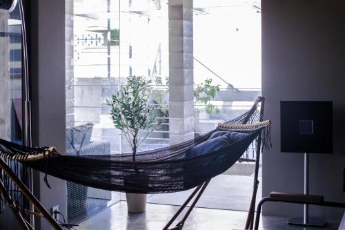 a hammock in a room with a large window at -Musée Villa- in Nakijin