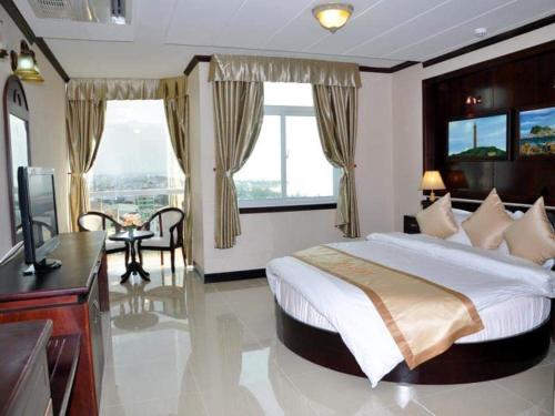 a bedroom with a large bed and a television in it at Sea Light Hotel in Rạch Giá