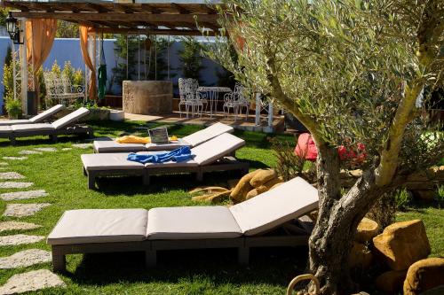 a patio with white couches and a tree at NINHO SALOIO in Venda do Pinheiro